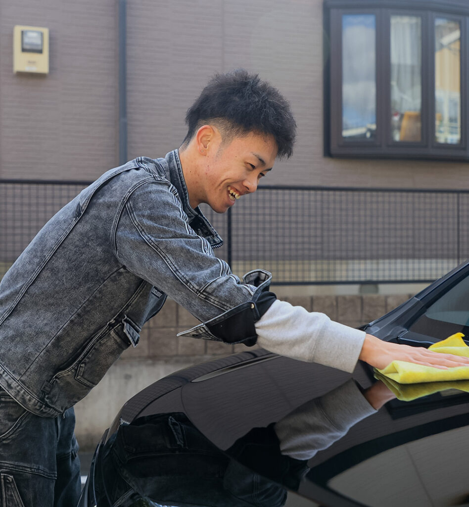 笑顔で洗車をする代表